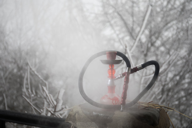 水烟，传统阿拉伯水管，直接日落光，户外照片。山的背景。户外。空的空间。图片下载