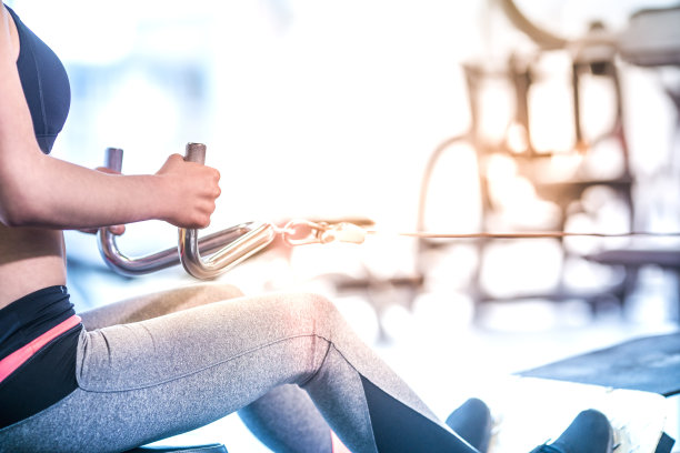 这个女人在健身房里握着训练器械上的杠杆图片下载