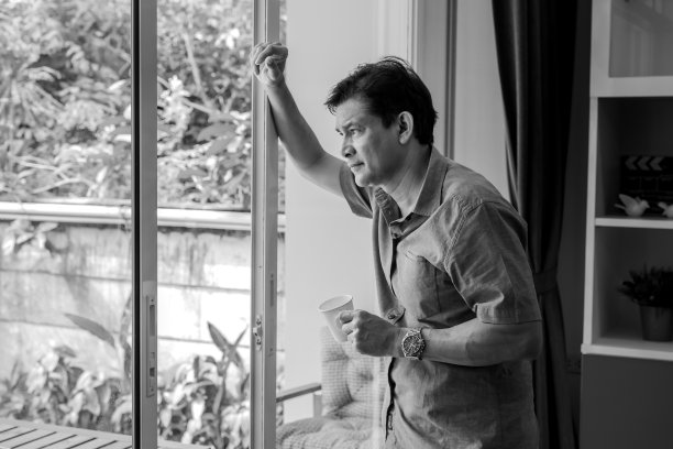 黑白图片，中年亚洲男子，喝着咖啡和使用想法，他是强调图片下载