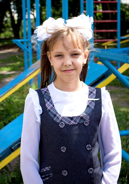 一个穿着校服的少女的肖像，背景是一所体校的操场图片下载