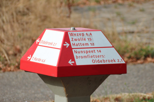 在荷兰的Veluwe上，有红色和白色蘑菇形状的荷兰城市名称的方向标志，供骑自行车的人使用图片下载