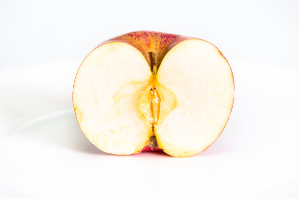 切成一半的红苹果放在白色的盘子上图片下载