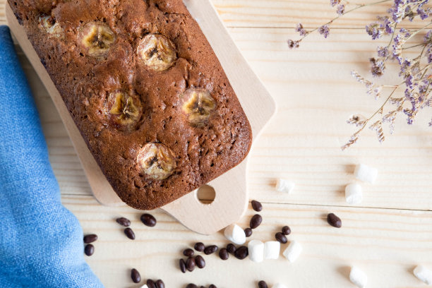自制松饼的照片，木质背景上有干花。自制烘焙。巧克力松饼配香蕉。巧克力香蕉蛋糕图片下载