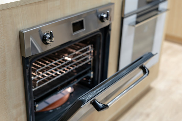 高角度视图照片打开门上的新和现代内置烤箱在光线明亮的厨房图片下载