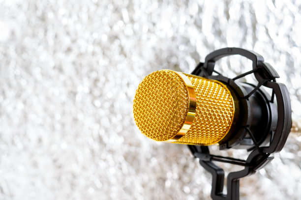 美丽的金色麦克风上的灯光模糊的背景，近，散焦。图片下载