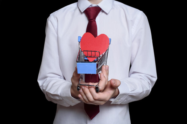 男孩拿着一个金属购物车，里面有一张心形的明信片。图片下载