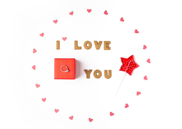 情人节的概念。爱情宣言，纸心相框，星星形状的棒棒糖。中间是带有戒指的红色礼品盒。平铺，俯视图，白色背景，孤立，复制空间图片下载
