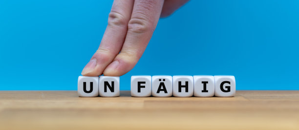 用骰子将德语单词“UNFÄHIG”(英语中的“无能”)拼成碎片，用两个手指将字母“UN”推开，即可将单词变为“FÄHIG”(英语中的“capable”)。图片下载