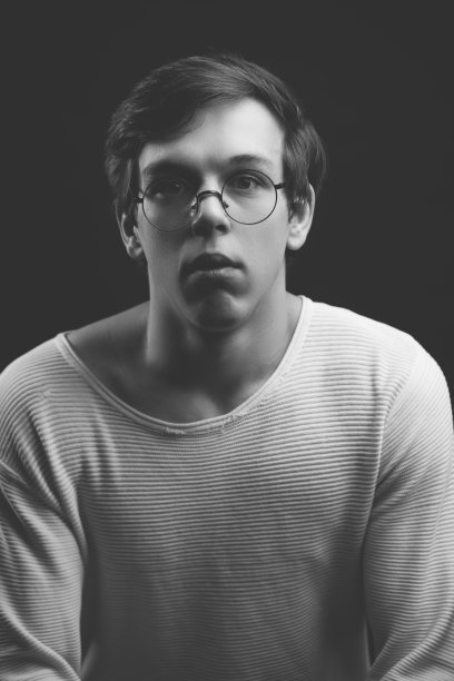 近距离的照片沉思的书呆子在圆形眼镜看着相机图片下载