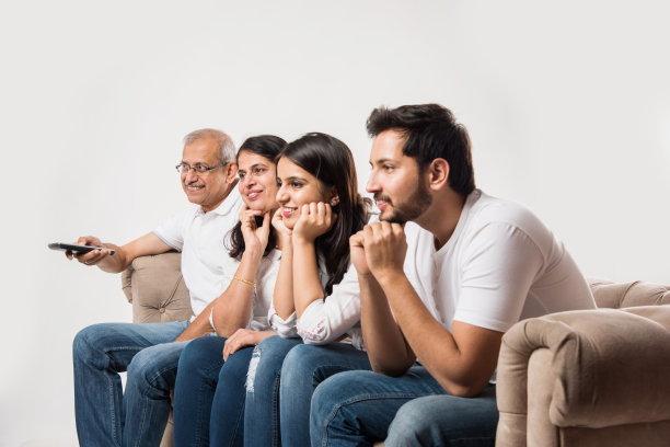 多代印度/亚洲家庭坐在沙发上看电视，选择性聚焦图片下载