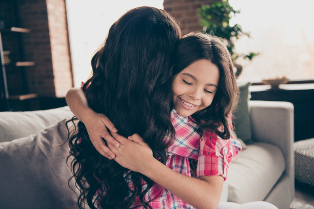 近距离的后面在后面的背影照片两个人拥抱妈妈小女儿眼睛闭上的心融化满意的深情穿着粉红色格子衬衫公寓房间坐舒适的沙发沙发沙发图片下载