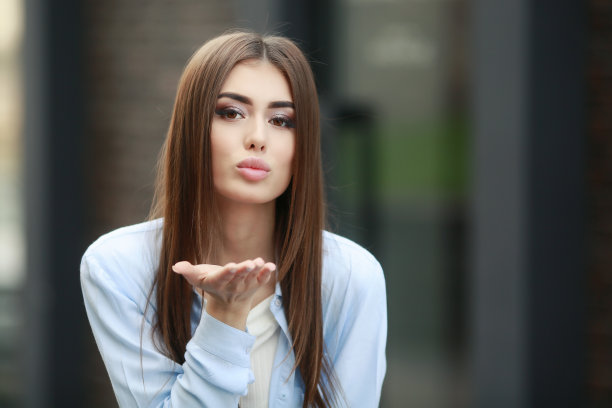 一个年轻的微笑美丽的亚洲女人的肖像与长黑发。生活方式图片的模特穿着白色t恤和蓝色的牛仔裤与刺绣图片下载