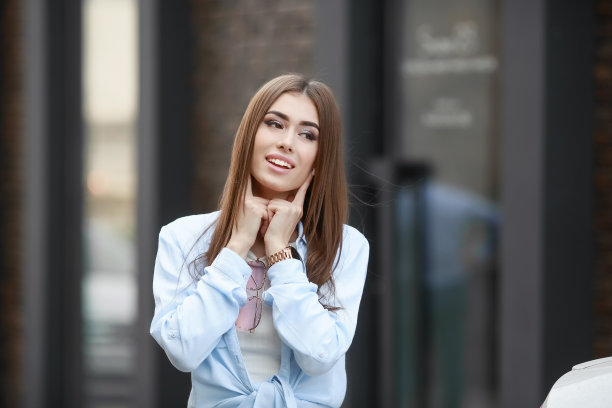 一个年轻的微笑美丽的亚洲女人的肖像与长黑发。生活方式图片的模特穿着白色t恤和蓝色的牛仔裤与刺绣图片下载