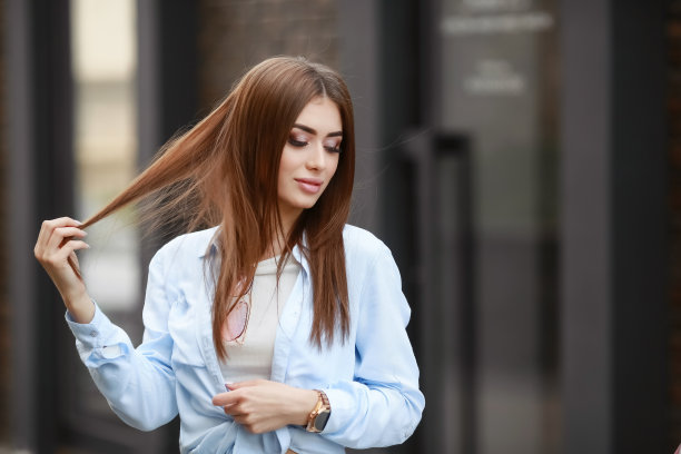 一个年轻的微笑美丽的亚洲女人的肖像与长黑发。生活方式图片的模特穿着白色t恤和蓝色的牛仔裤与刺绣图片下载