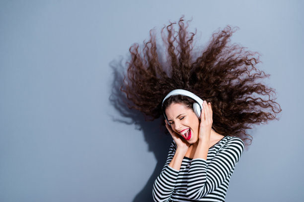 侧面侧面的特写照片肖像，相当无忧无虑的，无忧无虑的，愉快的，高兴的，高兴的，漂亮的女士拿着触摸用白色耳机尖叫的话，歌词孤立的，灰色的背景图片下载