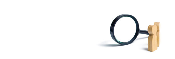 两个木制人像站在放大镜旁边，背景是白色。这个概念是为了寻找人和工人。寻找空缺职位和工作。人力资源、管理。横幅图片下载