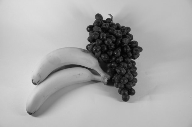 黑白照片。一串成熟美味的香蕉，三片和一串葡萄。图片下载