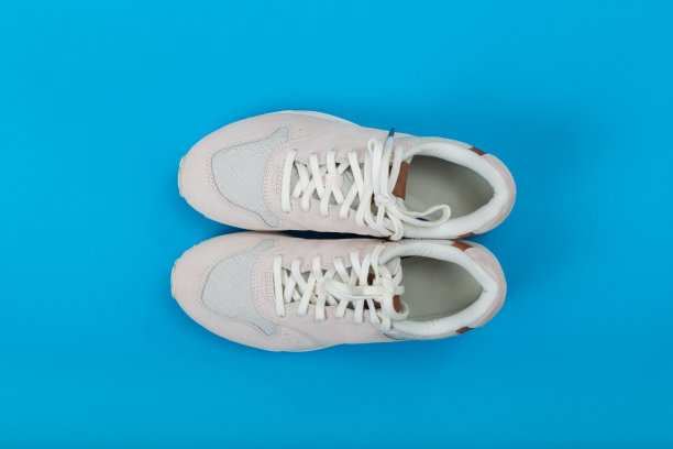 上方拍摄的白色运动鞋在纸蓝色的背景图片下载