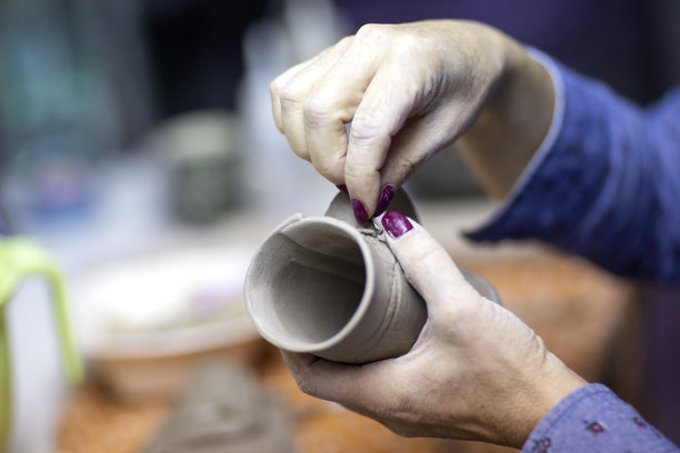 在工作室里用陶土制作马克杯的艺术家之手图片下载