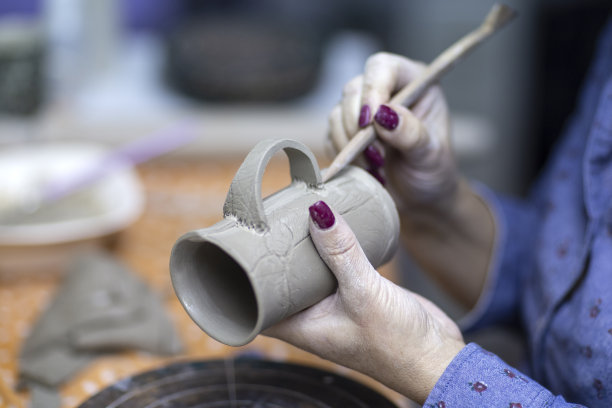 在工作室里用陶土制作马克杯的艺术家之手图片下载