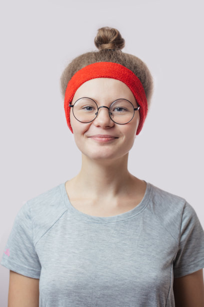 近距离的肖像微笑的女跑步者戴着发髻图片下载