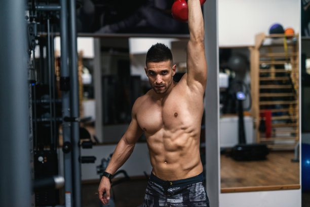 年轻的白种人赤膊肌肉男子与短头发做练习壶铃。健身房室内。图片下载