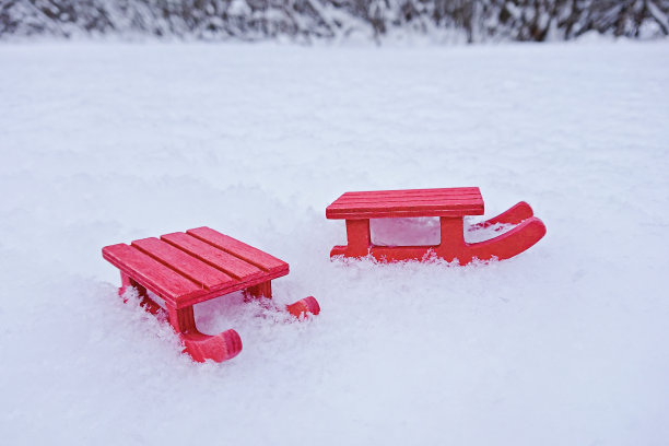 白色雪地上的迷你红色雪橇图片下载