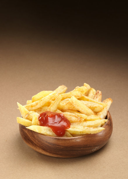 炸薯条装在盘子里，放在木桌上。图片下载