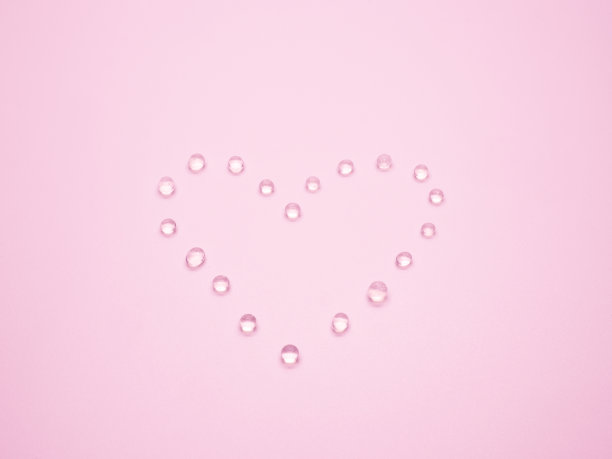 情人节概念与选择性焦点硅胶在粉红色的背景心形。图片下载