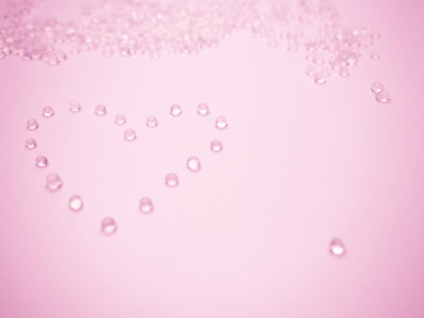 情人节概念与选择性焦点硅胶在粉红色的背景心形。图片下载