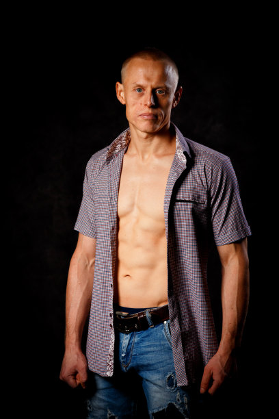 一个性感英俊的男人的肖像与肌肉的身体在一个未扣白衬衫图片下载