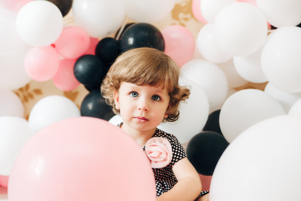 可爱的漂亮女孩的肖像。气球的背景。图片下载