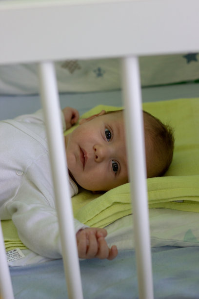 婴儿床里的小男孩醒了图片下载