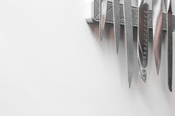 刀在磁性墙壁上支撑，在厨房的白色墙壁上，留出文字空间图片下载