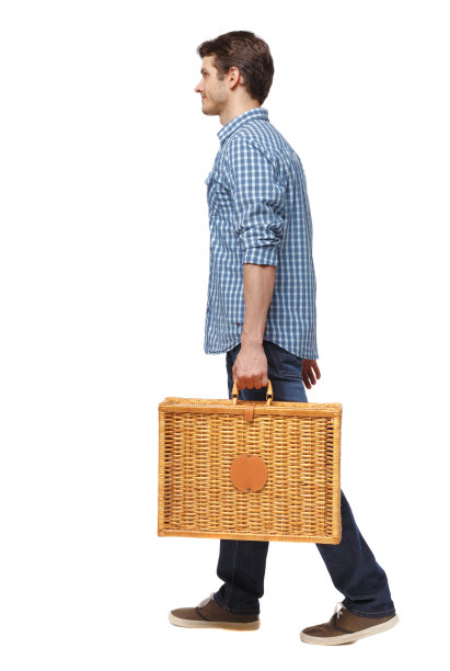 一个带着野餐袋走路的男人的侧视图。图片下载