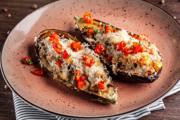 欧洲的西班牙美食。烤茄子配肉和蔬菜，帕尔马干酪。桌上有白葡萄酒。特写镜头的背景图片。餐厅里漂亮的上菜菜肴。图片下载