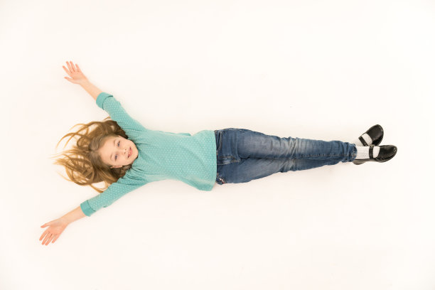 可爱的女孩躺在地板上。从上面的观点图片下载