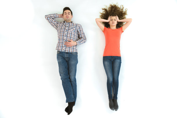 这对夫妇躺在白色的地板上。从上面的观点图片下载