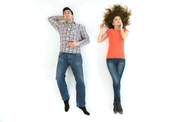 那个男人和女人躺在白色的地板上。从上面的观点图片下载