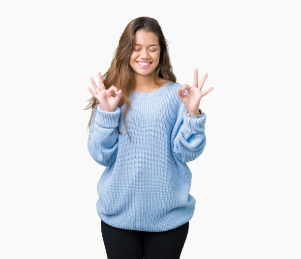年轻美丽的黑发女人穿着蓝色的冬天毛衣在孤立的背景放松和微笑闭上眼睛做冥想手势与手指。瑜伽的概念。图片下载