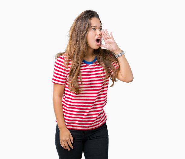 年轻美丽的黑发女人穿着条纹t恤在孤立的背景大喊大叫，一边与手在嘴上。通信的概念。图片下载