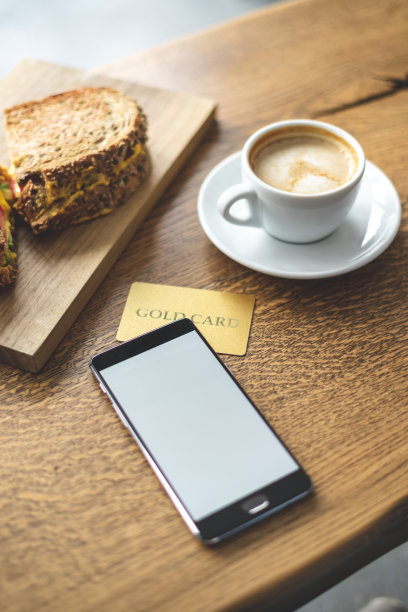 高角度以上的顶视图垂直和近距离的照片组的对象。便携式电话设备，咖啡和信用卡躺在阁楼内部空间的餐厅木桌图片下载