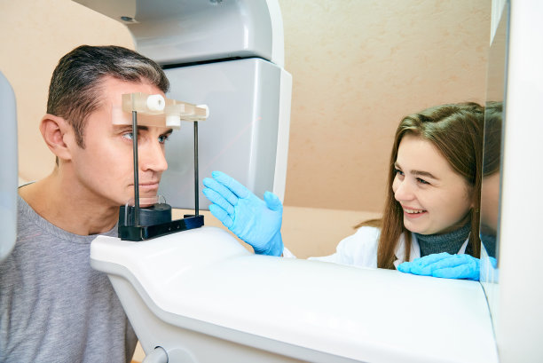 男病人在扫描仪里，女医生在控制面板附近图片下载