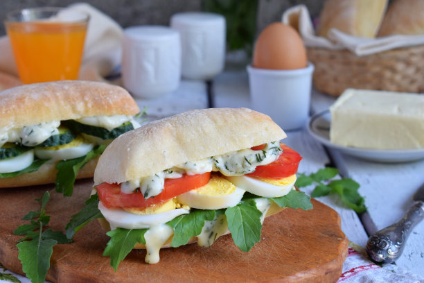 三明治由小面包、芝士酱、鸡蛋、芝麻菜、番茄和黄瓜组成。早餐或零食。素食。健康饮食的概念。乡村的照片。本空间图片下载