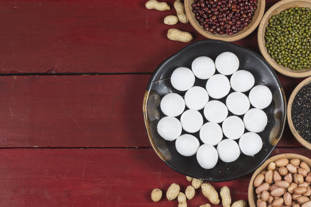 汤圆放在碗里放在桌上，红包和金元宝素材图片