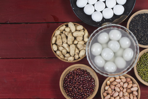 汤圆放在碗里放在桌上，红包和金元宝素材图片