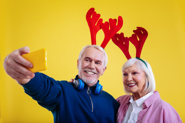 退休男子拿着手机和妻子拍照图片下载