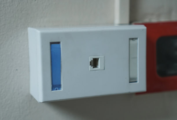 特写一根以太网电缆插入墙上的插座，物联网连接的概念图片下载