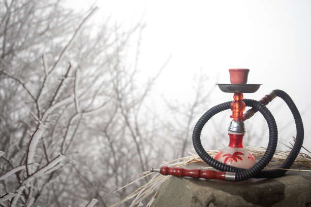 水烟，传统阿拉伯水管，直接日落光，户外照片。山的背景。户外。空的空间。图片下载