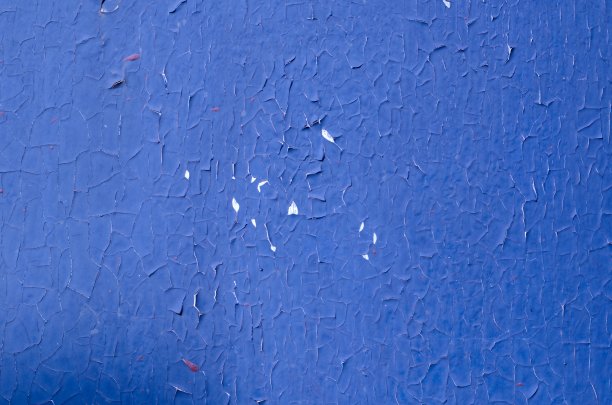照片的旧和剥落的蓝色色调裂石膏墙面近距离作为艺术背景和纹理。图片下载